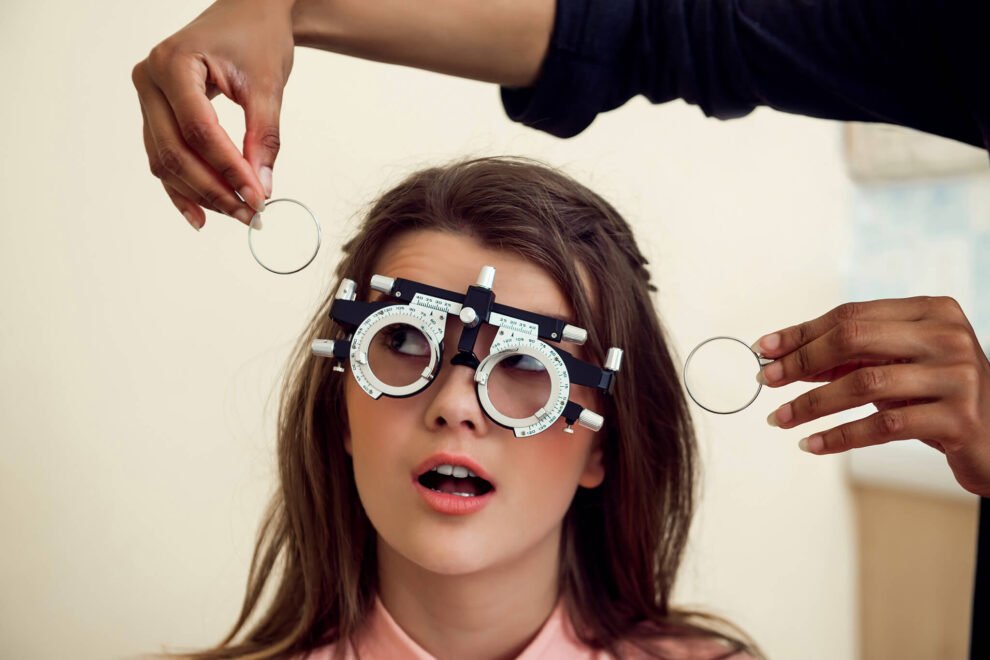 eyecare-health-concept-portrait-curious-entertained-young-european-woman-sitting-chair-while-eyecare-specialist-testing-sight-with-phoropter-asking-if-she-can-see-clearly